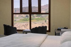 a bedroom with a bed and a window with a view at Alsharafh room 2 in Al ‘Aqar