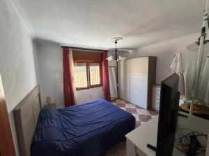 a bedroom with a blue bed and a window at Chalet con Piscina Aguadulce in Aguadulce +27 photos