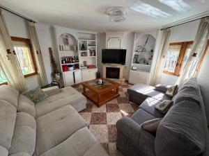 a living room with two couches and a television at Chalet con Piscina Aguadulce in Aguadulce