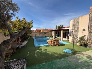 a backyard with a swimming pool and green grass at Chalet con Piscina Aguadulce in Aguadulce