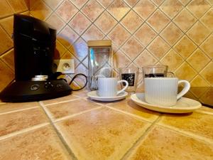 two coffee cups on a kitchen counter with a coffee maker at À minnanna in Banon