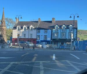 a street with a blue building and a church at 7 The Diamond in Ballycastle