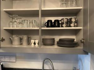a kitchen shelves filled with dishes and glass jars at 7 The Diamond in Ballycastle +7 photos