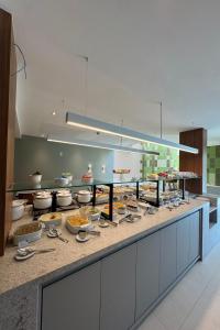 a kitchen with a buffet with food on a counter at Hotel Acalanto Feira de Santana in Feira de Santana +31 photos