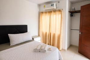 a bedroom with a bed with two slippers on it at Acogedor apartamento in Leticia