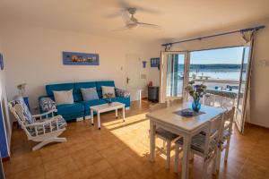 a living room with a blue couch and a table at SOL NAIXENT in Fornells