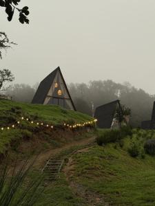 a house on top of a grassy hill with lights at NIDU Cabañas Boutique & Holística in Mineral del Monte +46 photos