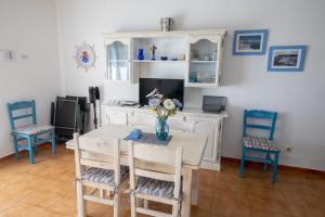 a dining room with a table and blue chairs at SOL NAIXENT in Fornells