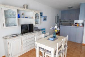 a dining room with a table and a tv at SOL NAIXENT in Fornells