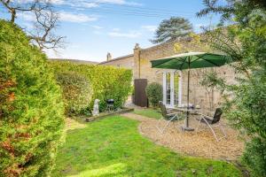 a garden with a table and an umbrella at 1 Bed in Beccles oc-65080 in Beccles