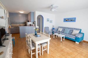 a living room with a table and chairs and a couch at SOL NAIXENT in Fornells