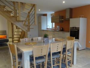 a kitchen with a table with chairs and a staircase at Airellier du Pilat in Marlhes