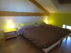 a bedroom with a bed with two lamps on it at Airellier du Pilat in Marlhes