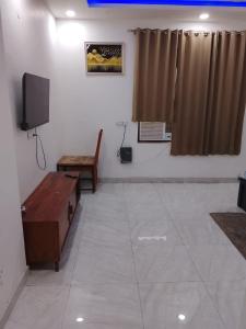 a living room with a tv and a table and a couch at Hotel elite in Palwal
