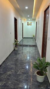 an empty hallway with potted plants in a building at Hotel elite in Palwal