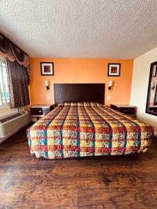 a bedroom with a large bed with a colorful blanket at Walden Motel in Las Vegas