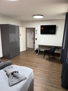 a hotel room with a bed and a flat screen tv at Garland-Rooms in Bremen