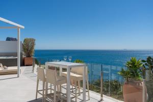 a white table and chairs on a balcony with the ocean at Maryvilla Inspiración y Vacaciones - Villa Mascarat in Calpe