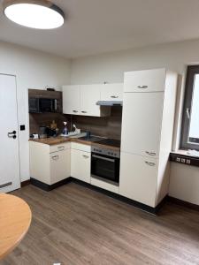an empty kitchen with white cabinets and a table at Garland-Rooms in Bremen