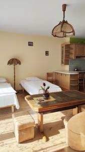 a room with two beds and a table in it at Apartament Ziołowy in Augustów