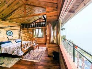 a bedroom in a log cabin with a bed on a balcony at Cloudwalks Homestay in Kodaikānāl