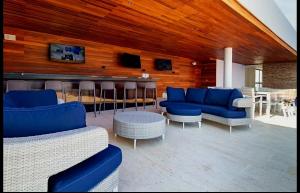 a living room with blue couches and a bar at Depa MAJUM Playa del Carmen in Playa del Carmen