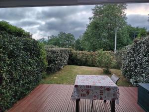 a table and chair sitting on a wooden deck at Euskal Herria in Saint-Pée-sur-Nivelle