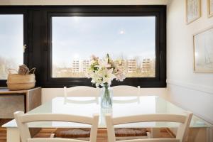 a white dining room table with a vase of flowers at Strandhaferweg 7 Beach Apartment Fehmarn in Burgtiefe auf Fehmarn 