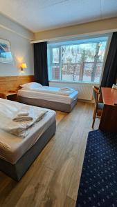 a hotel room with two beds and a window at Hótel Austur in Reyðarfjörður