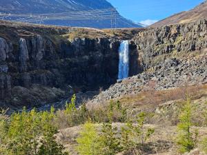 a waterfall on the side of a mountain at Hótel Austur in Reyðarfjörður