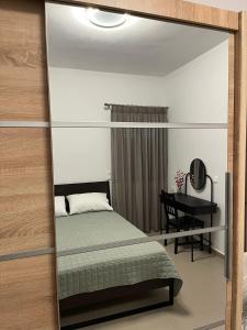 a mirror in a bedroom with a bed and a desk at Nenes Apartment in Koroni