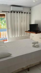 a bedroom with a bed with two towels on it at Casa Brasil pousada e lazer in Trindade