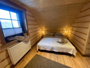a bedroom with a bed in a wooden room at Domek u Hillów in Stronie Śląskie