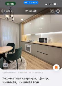 a kitchen with white cabinets and a table and chairs at DOR ApartHotel in Chişinău