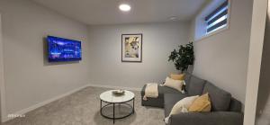 a living room with a couch and a table at Cobblebrook Executive Suites in Airdrie
