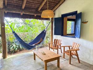 a hammock in a room with chairs and a table at Casa Botanique Jungle Retreat in Abraão +43 photos