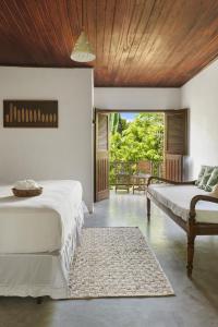 a bedroom with two beds and a couch in it at Pousada Nativa in Caraíva +122 photos