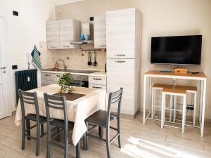 a kitchen with a table with chairs and a television at Ninfa del lago - PRIVATE GARAGE in Colico