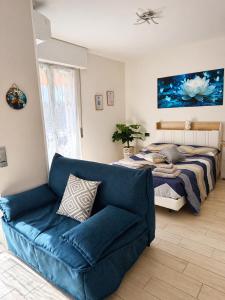 a bedroom with a bed and a blue couch at Ninfa del lago - PRIVATE GARAGE in Colico