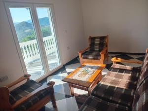 a living room with two chairs and a coffee table at Shtepia e Bardhe in Grykë-Orosh