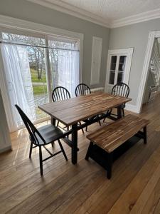 a dining room with a wooden table and chairs at Breakwater Lodge in Lower Woods Harbour +17 photos