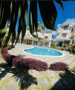 a swimming pool in front of a building at Sea La Vie Villa in Grande Gaube