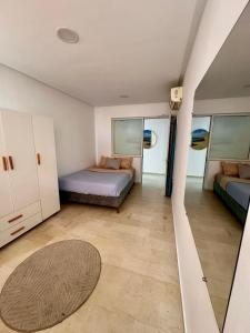 a bedroom with two beds and a rug at Appartement Laetitia, hyper centre hammamet in Hammamet