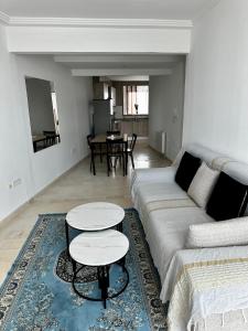 a living room with a couch and two tables at Appartement Laetitia, hyper centre hammamet in Hammamet