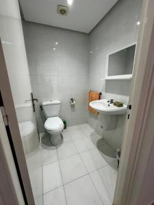 a white bathroom with a toilet and a sink at Appartement Laetitia, hyper centre hammamet in Hammamet +19 photos