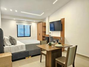 a bedroom with a bed and a table and a dining room at Hotel Casa Cristales in Cali
