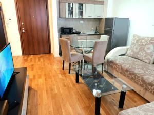 a living room with a glass table and a couch at HUGO APARTMAN Green Hill Kompleks- u blizini Akva Parka in Soko Banja