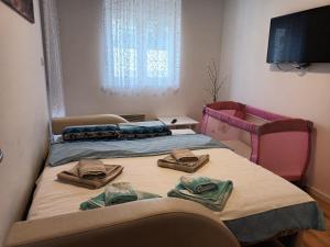 two beds in a room with towels on them at HUGO APARTMAN Green Hill Kompleks- u blizini Akva Parka in Soko Banja +38 photos