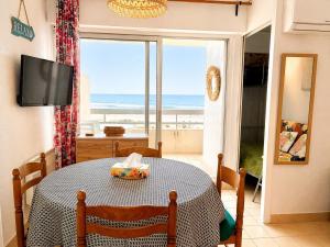 a dining room with a table and a view of the ocean at Studio cabine pied dans l eau climatisé, parking et wifi haut débit in Canet-en-Roussillon