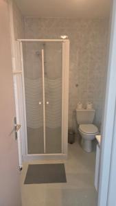 a bathroom with a glass shower with a toilet at Résidence Mauriac in Mauriac